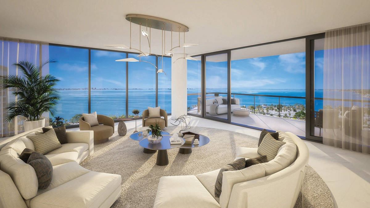 Bright living room with curved sofas and floor-to-ceiling windows overlooking Sarasota Bay
